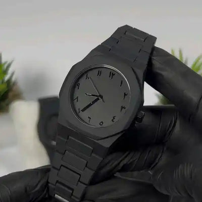 Black watch held by a gloved hand with a blurred background
