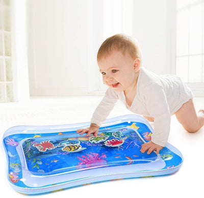 Baby playing with an inflatable water mat on a light-colored floor.