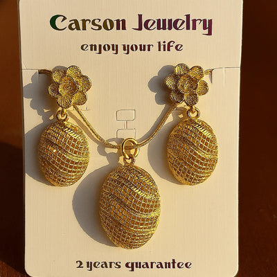 Gold earrings on a Carson Jewelry card with a brown background