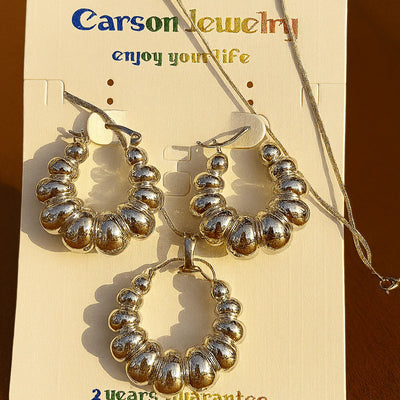 Silver hoop earrings and necklace set on a Carson Jewelry card.